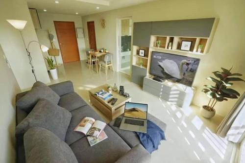 a living room with a couch and a tv at The Two bedrooms Two bathrooms in Phuket Old Town in Phuket