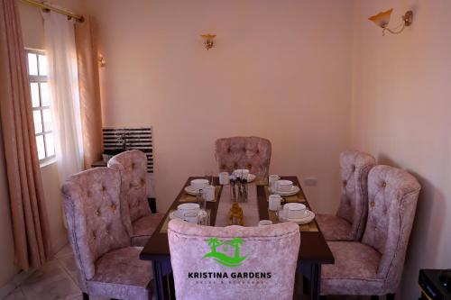 a dining room with a table and chairs at Kristina Gardens in Voi