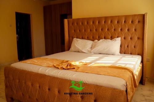 a bed in a hotel room with a large headboard at Kristina Gardens in Voi