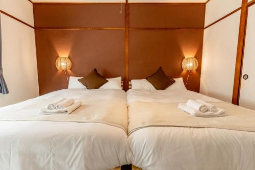 two beds in a room with towels on them at リトリートタワー天神 in Fukuoka