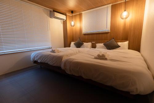 a bedroom with a large bed with two stuffed animals on it at リトリートタワー天神 in Fukuoka