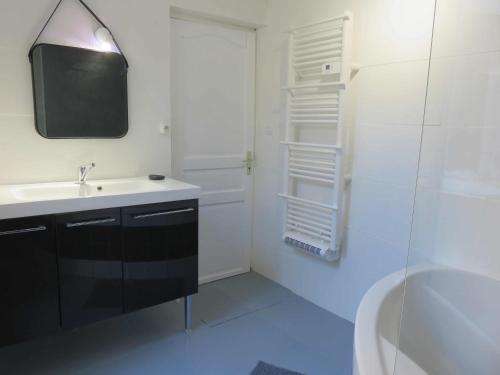 une salle de bain blanche avec un lavabo et une douche dans l'établissement Le 14 - 1 Chambre hyper centre, à Béziers