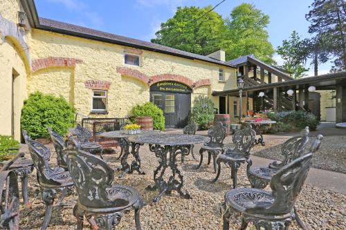 a group of chairs and tables in front of a building at Carrygerry Country House in Shannon