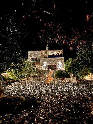 a stone house with lights in front of it at Armenopetra View Gerolimenas in Gerolimenas