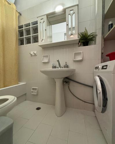 a bathroom with a sink and a washing machine at Ναϊάδες in Konístrai