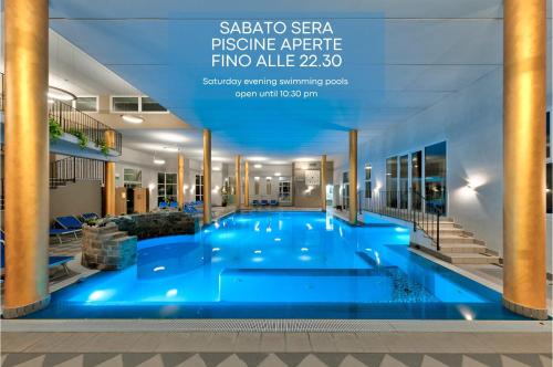 una grande piscina con acqua blu in un edificio di Hotel Terme Belsoggiorno ad Abano Terme