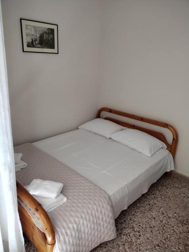 a bed in a white room with a wooden frame at Ναϊάδες in Konístrai