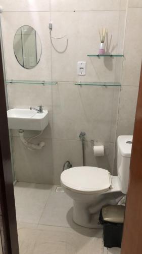a bathroom with a toilet and a sink and a mirror at Pousada Valley House in Piranhas