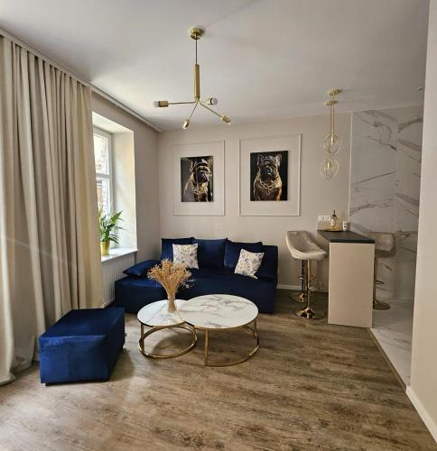 a living room with a blue couch and a table at Golden Key 35m2 aprtament blisko Dworzec, Spodek, MCK, Self check-in, Parking in Katowice