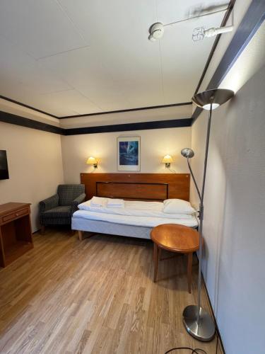 a bedroom with a bed and a chair and a couch at Camp Skytterhuset in Hammerfest