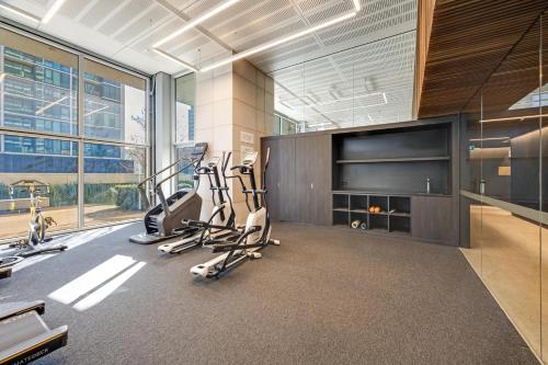 a gym with cardio equipment and a large window at Nest Apartments on Rose Lane in Melbourne