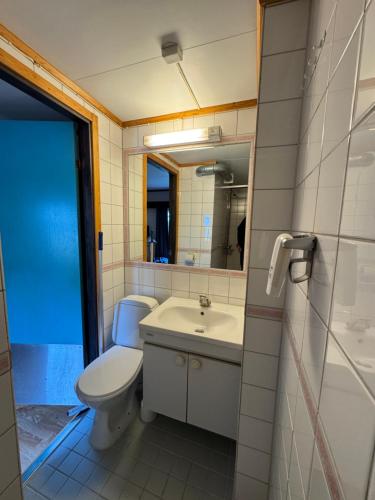 a bathroom with a toilet and a sink and a mirror at Camp Skytterhuset in Hammerfest