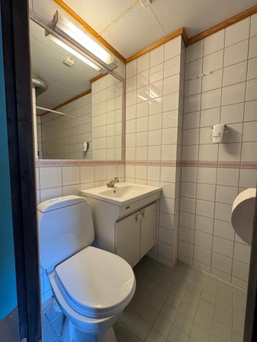 a bathroom with a white toilet and a sink at Camp Skytterhuset in Hammerfest