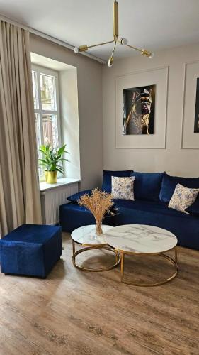 a living room with a blue couch and a coffee table at Golden Key 35m2 aprtament blisko Dworzec, Spodek, MCK, Self check-in, Parking in Katowice