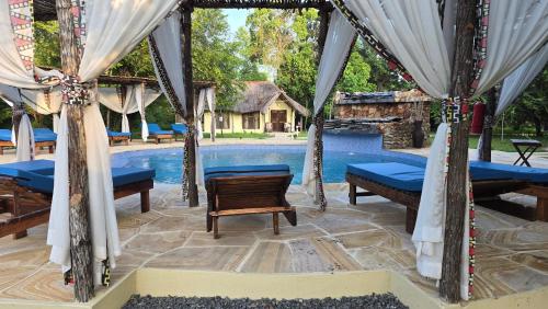 a pavilion with tables and chairs next to a pool at Africa Safari Selous Nyerere national park in Nyakisiku