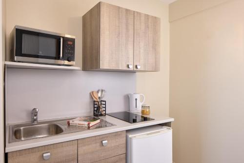a kitchen with a sink and a microwave at Zenitude Hôtel-Résidences Le Havre Les Docks in Le Havre