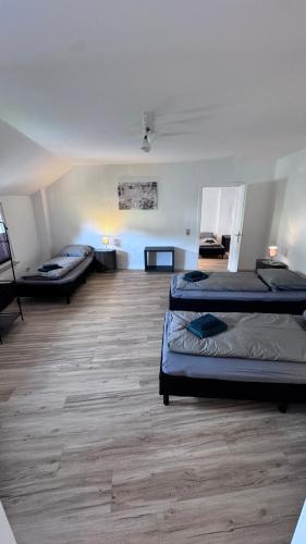 a room with three beds and a wooden floor at 24-7 Living - Unna Central City Apartments in Unna