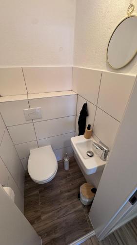a small bathroom with a toilet and a sink at 24-7 Living - Unna Central City Apartments in Unna