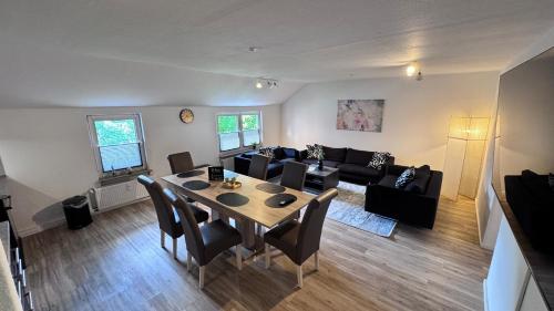 a living room with a table and a couch at 24-7 Living - Unna Central City Apartments in Unna