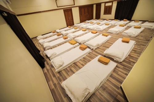 a group of beds in a row in a room at M3 Homestay in Madurai