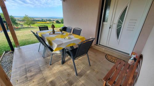 a table with chairs and a yellow and white table cloth at Holiday home Vinovilla in Kutjevo