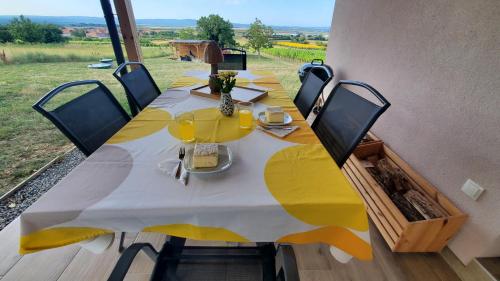 a large yellow table with chairs and a large window at Holiday home Vinovilla in Kutjevo