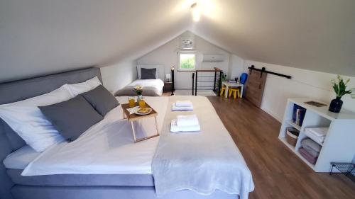 a living room with a white bed and a room with a bed sqor at Holiday home Vinovilla in Kutjevo
