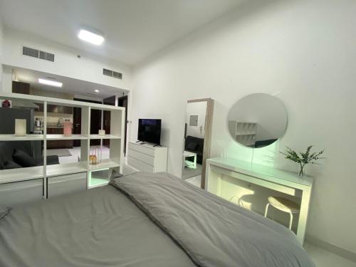a bedroom with a bed and a desk and a mirror at Dubai Silicon Oasis Holiday Homes in Dubai