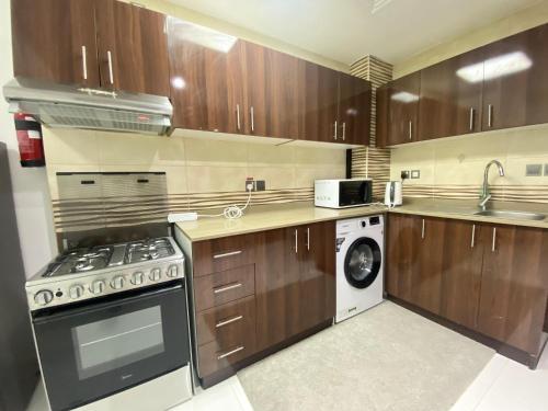 a kitchen with wooden cabinets and a washer and dryer at Dubai Silicon Oasis Holiday Homes in Dubai