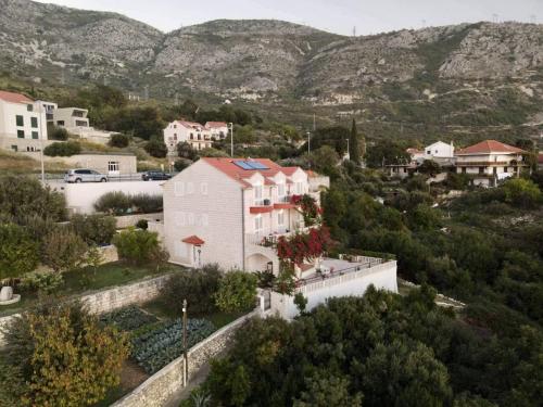 a house in a town with mountains in the background at Villa Panorama Dubrovnik in Mlini
