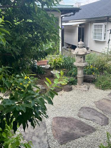 a garden with a fire hydrant in front of a house at サンムーン鶴間 in Yamato