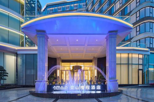 a blue building with a fountain in front of it at Arula Mianyang Jianshan Hotel-绵阳见山檀程酒店 in Mianyang
