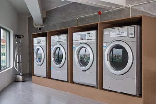 a row of washing machines in a laundry room at Arula Mianyang Jianshan Hotel-绵阳见山檀程酒店 in Mianyang