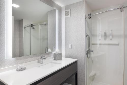 a white bathroom with a sink and a shower at Hampton Inn & Suites Portsmouth Downtown in Portsmouth