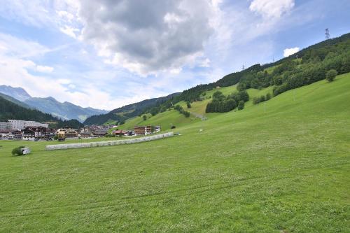 a green field with a town on a hill with mountains at Haus Hildegard in Gerlos