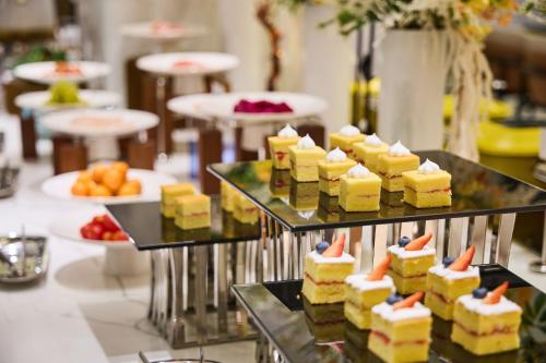 a bunch of desserts on display in a buffet at Arula Mianyang Jianshan Hotel-绵阳见山檀程酒店 in Mianyang