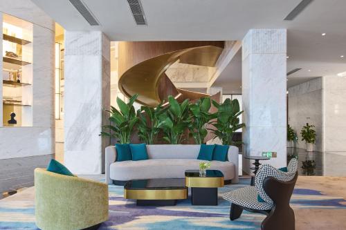 a living room with a couch and a chair at Arula Mianyang Jianshan Hotel-绵阳见山檀程酒店 in Mianyang