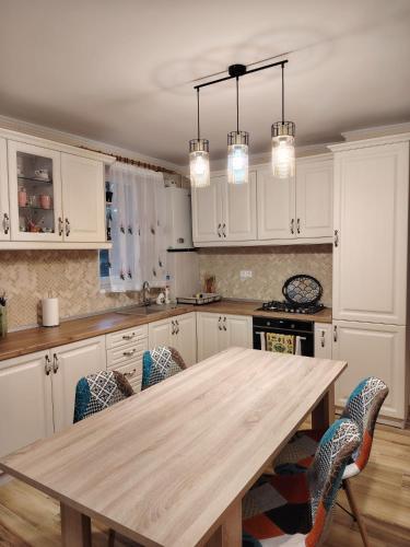 a kitchen with a wooden table and chairs at Apartament Confort Dambul Pietros Targu-Mures in Târgu-Mureş