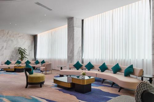 a waiting room with couches and chairs and windows at Arula Mianyang Jianshan Hotel-绵阳见山檀程酒店 in Mianyang