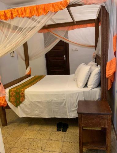 a bed in a room with a canopy bed at Princess Salme Inn in Zanzibar City