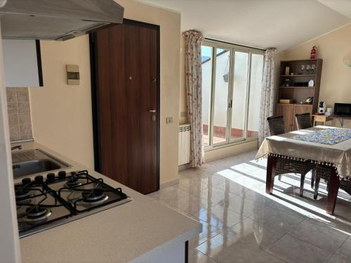 a kitchen with a stove top oven next to a table at La mia dolce casa in Mascali