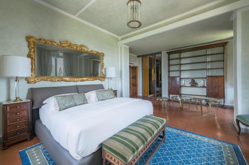a bedroom with a large white bed and a mirror at Villa Leonardo - Vinci in Vinci