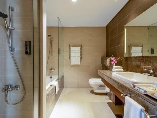 a bathroom with a sink and a toilet and a shower at Flora Al Barsha Hotel At The Mall in Dubai