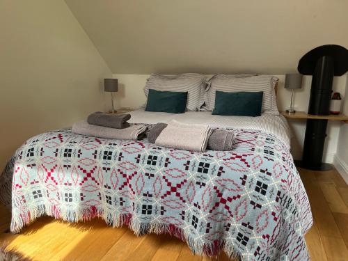 a bedroom with a bed with a red and white quilt at Maes Y Grove Garden Cottage in Llanddarog