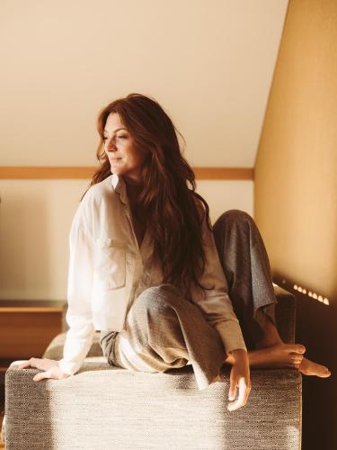 a woman sitting on the back of a chair at Arlberg Lodges in Stuben am Arlberg