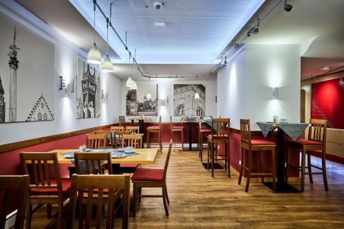 a restaurant with tables and chairs and a bar at Hotel & Gasthaus DAS RÖHRL Straubing in Straubing