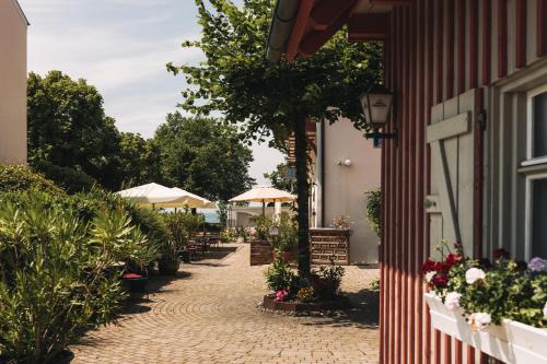 a cobblestone street with flowers and umbrellas on a building at SeeHotel Amtshof in Langenargen