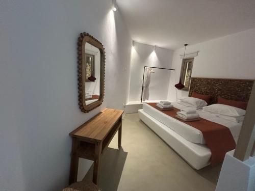 a bedroom with a bed and a mirror and a table at ANDELIAS Signature Suites in Chora Folegandros