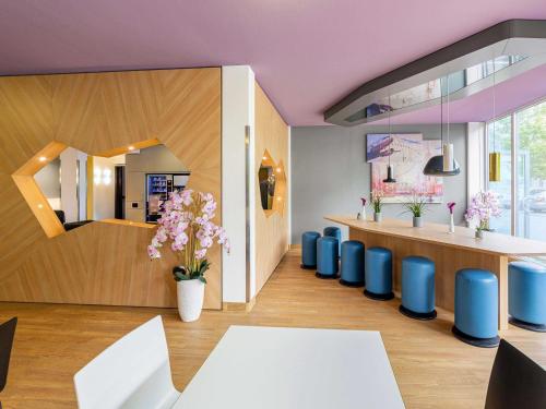 a restaurant with purple ceilings and blue chairs at B&B Hotel Düsseldorf-Airport in Düsseldorf
