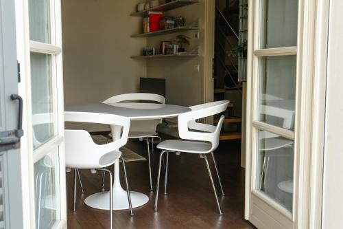 a dining room with a table and white chairs at Residenza Castello, con Ampio Garage Privato in Crema